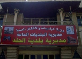 قوة أمنية تداهم مبنى بلدية الحلة وتعتقل (مسؤولي الإيجارات والإعلانات فيها)