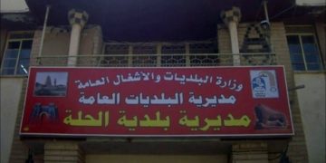 قوة أمنية تداهم مبنى بلدية الحلة وتعتقل (مسؤولي الإيجارات والإعلانات فيها)