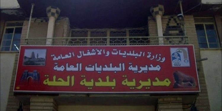 قوة أمنية تداهم مبنى بلدية الحلة وتعتقل (مسؤولي الإيجارات والإعلانات فيها)