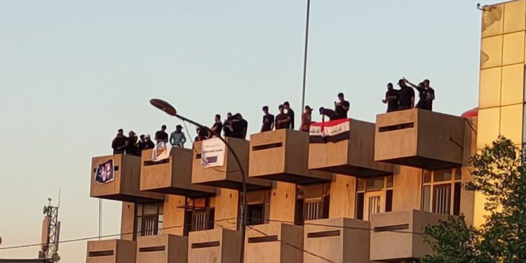 متظاهرون يعتلون على بناية قريبة من الخضراء تقليداً للمطعم التركي