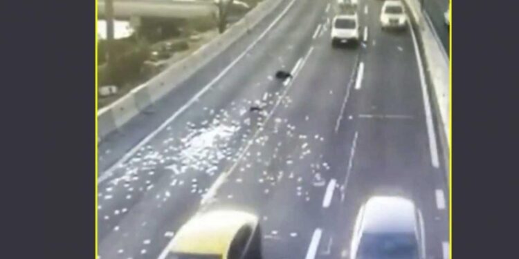 عصابة تلقي آلاف الدولارات على طريق سريع + فيديو