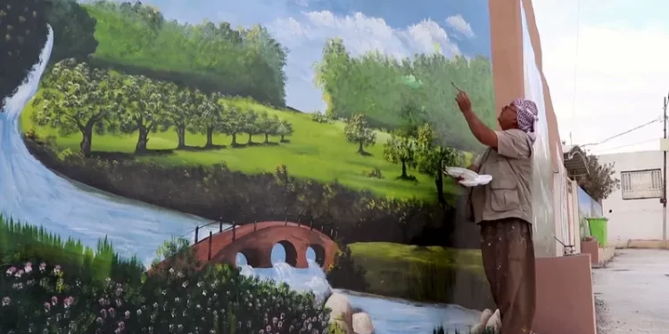 عراقي يزيّـــن ساحة قريته باللوحات الجدارية