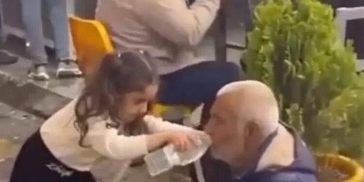 بالفيديو ..طفلة عراقية تخطف القلوب  ,, تسقي مشردًا بيديها