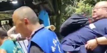 رجل صيني يستأجر 9 أشخاص لحمله على الأعناق إلى تمثال إله الثروة